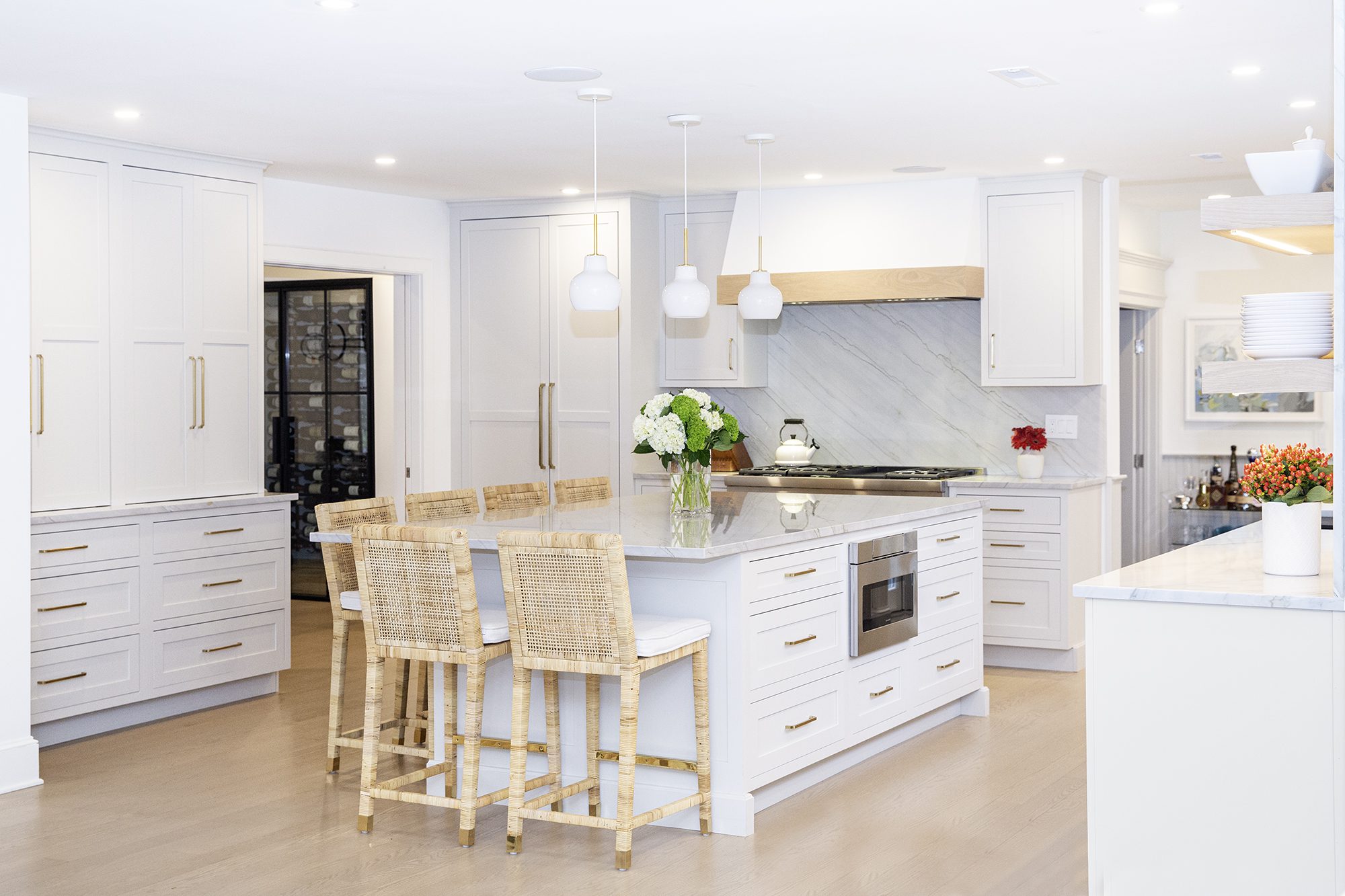 Clean and open kitchen design with white cabinets and walls and wooden accents.
